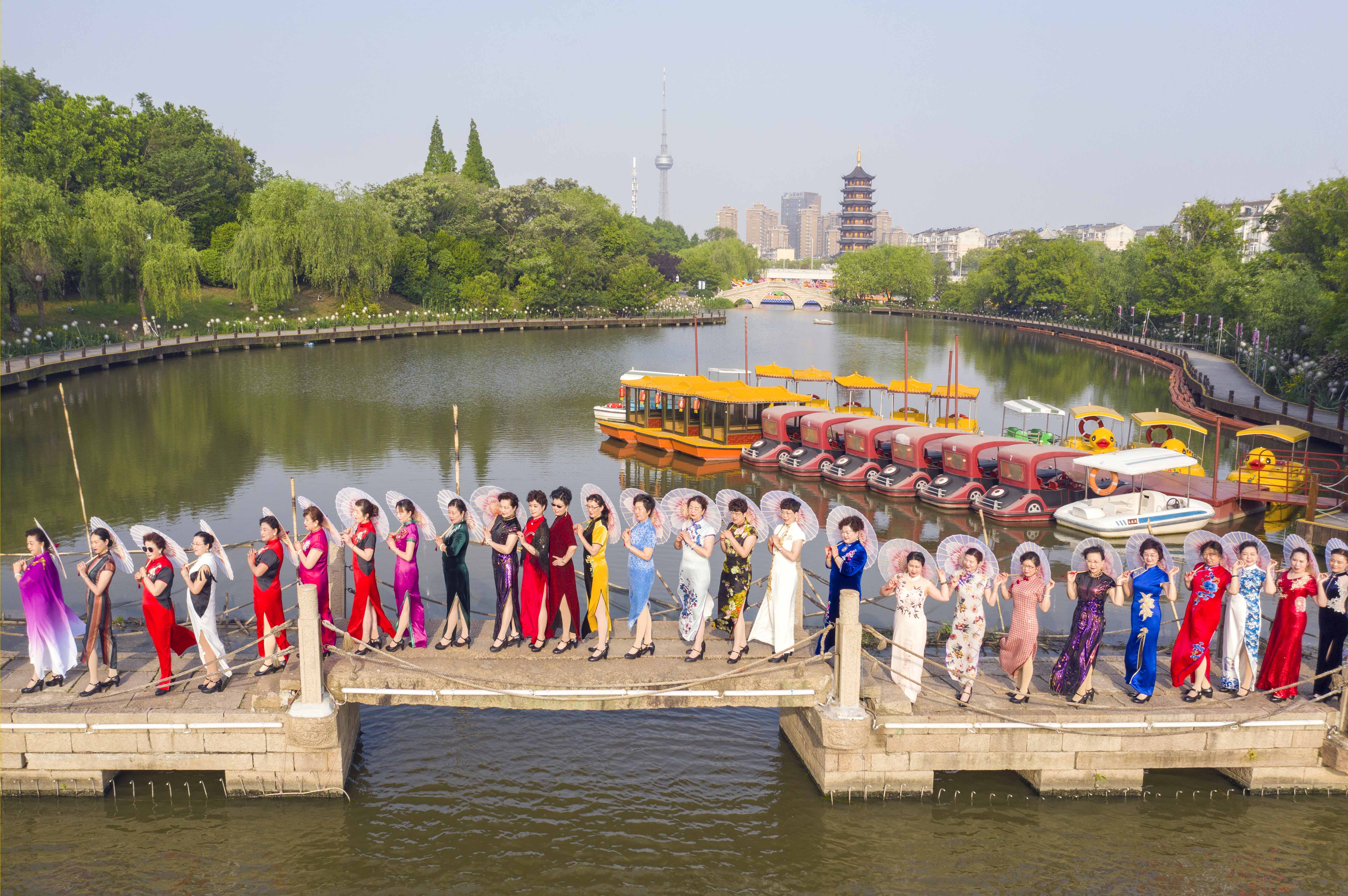2021年5月9日,旗袍爱好者在泰州市凤城河景区三水湾展示旗袍.