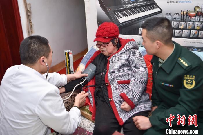 2月27日，中队卫生员给刘玉珍测量血压。　唐志勇 摄