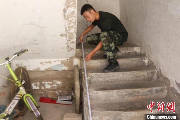 2018年9月，中队司务长张伟波为刘玉珍家的楼梯安装护栏。　武警重庆总队执勤第四支队 供图