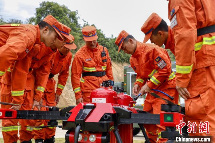 楼应佳与队员一同研究新型无人机。　福建省森林消防总队供图