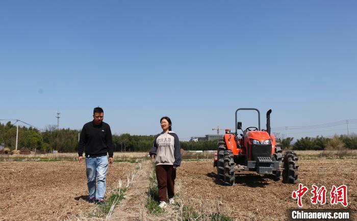 农技人员向周丹介绍种粮政策补贴 项菁 摄
