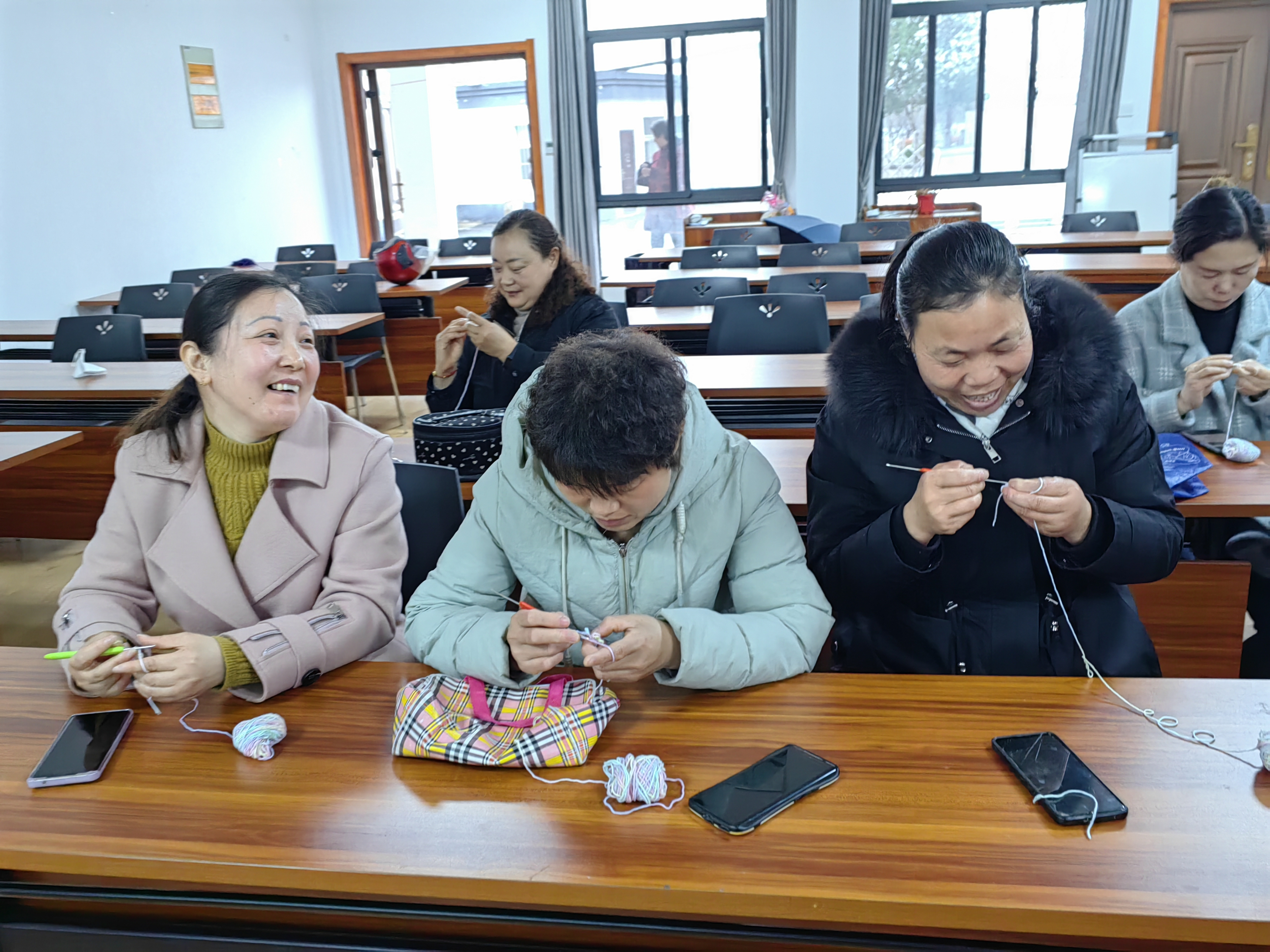 江宁周村社区就业服务站把大龄就业人员组织起来做手工饰品在附近景点销售。