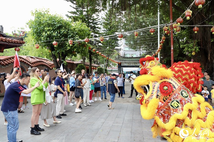 看到海澄城隍庙舞狮精彩表演，中外媒体采访团的成员们纷纷拿出手机拍照记录。人民网 谢小姿摄