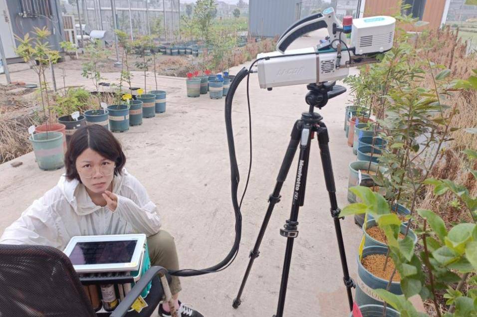 李胜兰在扬州绿色农业研究与示范基地测植物光合。南京信息工程大学供图