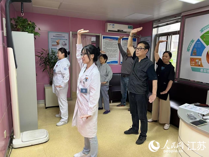 申进和家庭医生一起练习八段锦。人民网记者 马晓波摄