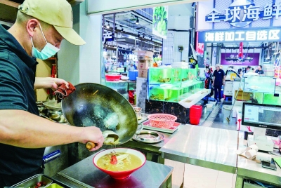 在位于江宁区通淮街的“刘姐菜篮子”太平店，消费者在海鲜加工自选区选购食材后，厨师现场加工烧制菜品。 南京日报/紫金山新闻记者 戚珂嘉 摄