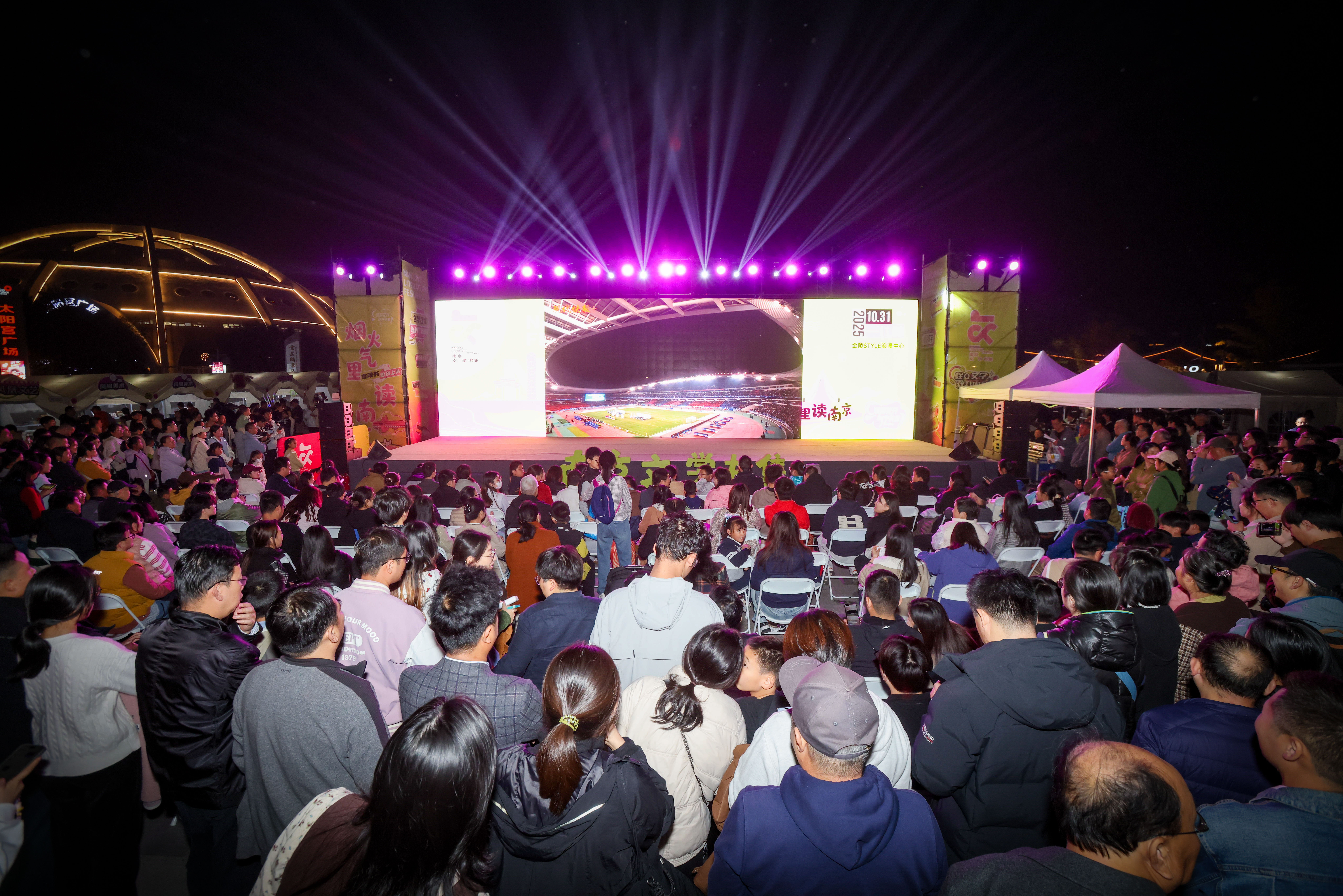 南京金陵STYLE浪漫中心的广场上，众多球迷聚集在户外大屏前观看赛事直播。